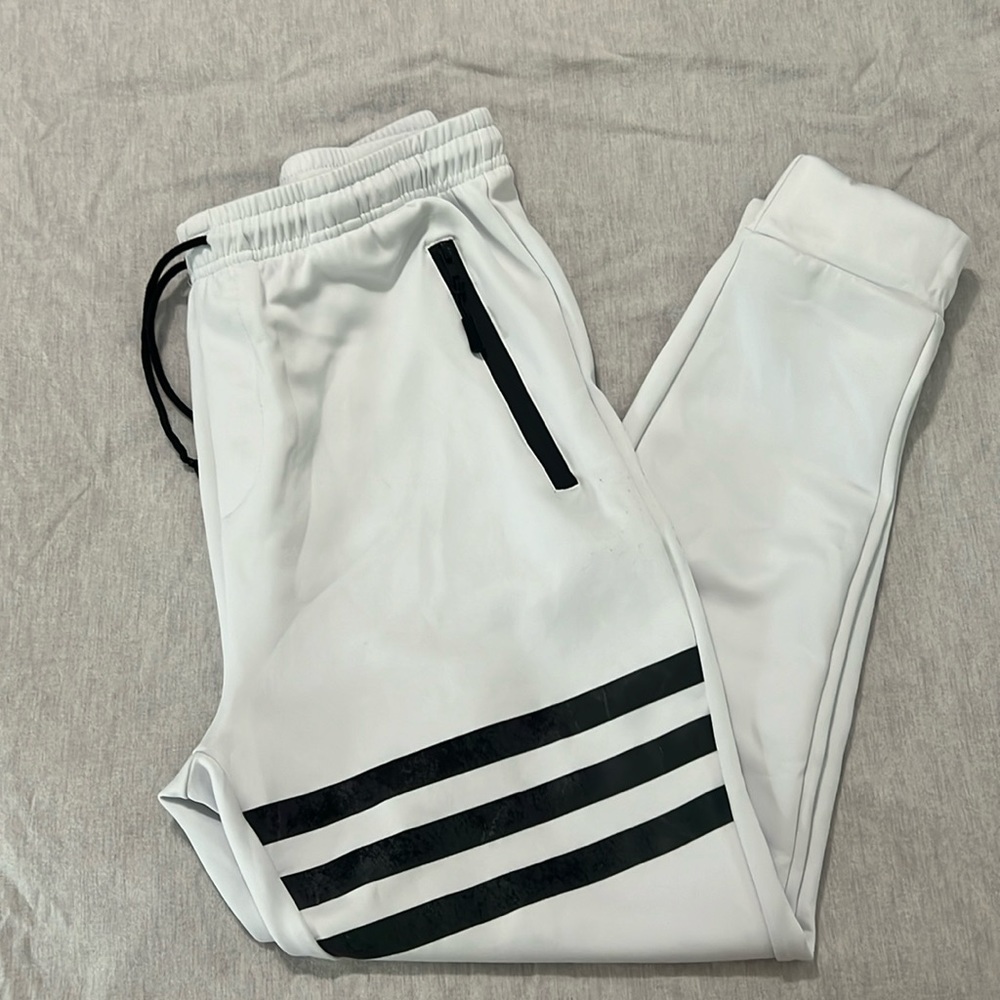 White athletic pants with black strips on one leg